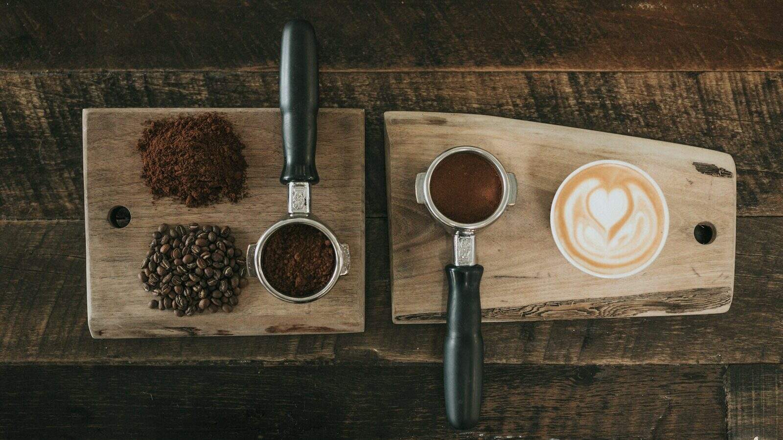coffee beans beside coffee powder on brown wooden board